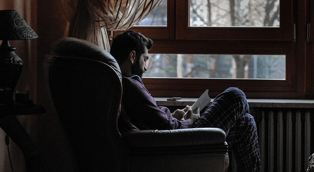 man-seated-sofa-reading
